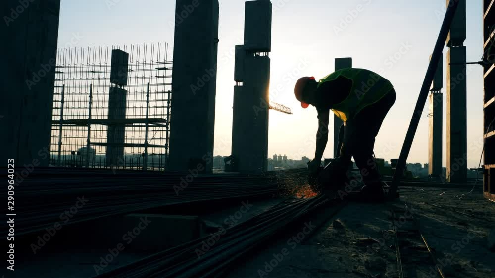 A worker uses disk saw on a construction site.