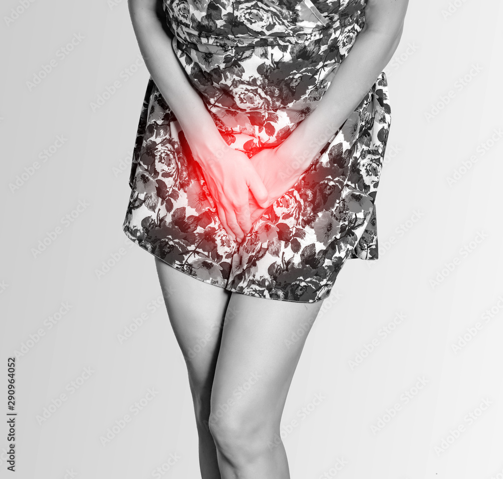 Woman in a colored dress presses her hands to her stomach, experiences