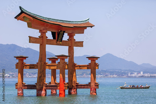 Wallpaper Mural A large wooden red torii emerging from the water with a traditional boat nearby and the distant skyline of Hiroshima in the background Torontodigital.ca