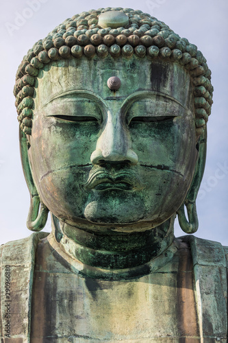 Symmetrical close up of the head of a giant bronze buddha statue