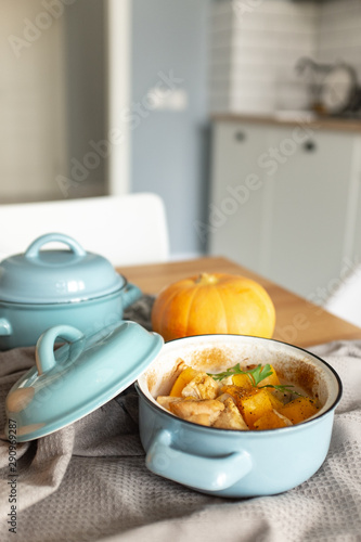 Pumpkin roast in a blue pan on a wooden table