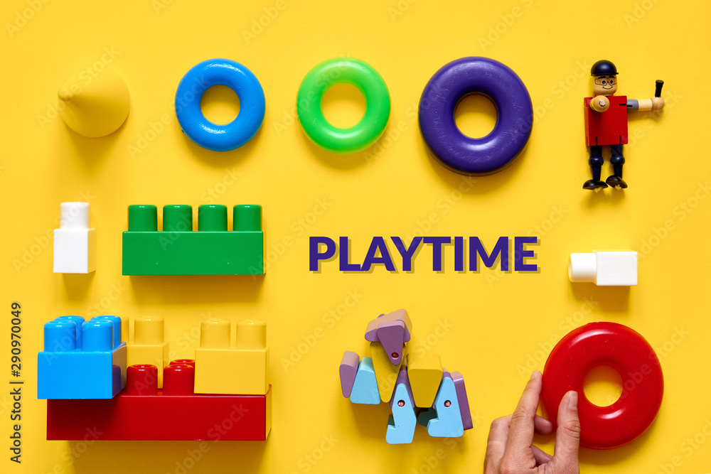 Flat lay of plastic and eco wooden toys. Developing games. Yellow background Flat lay of plastic and eco wooden toys. Developing games. Yellow background