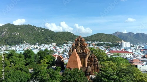 Aerial video footage of popular tourist destination of Nha Trang on the South Central Coast of Vietnam featuring the Cham towers of po nagar, and views to urban and mountain areas in bright sun photo