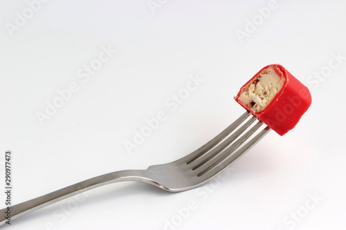 piece of curd cheese on a fork on a white background