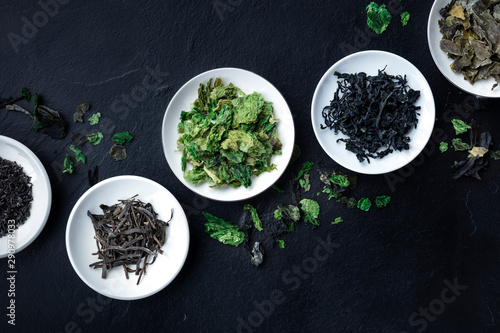 Murais de parede Various dry seaweed, sea vegetables, shot from the top on a black background wit