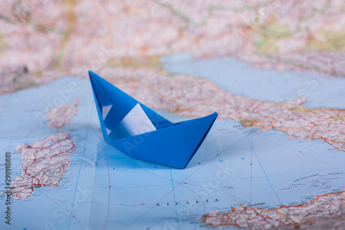 Travel holiday vacation concept origami tourist handmade papercraft paper ship on map near italy close up studion shot