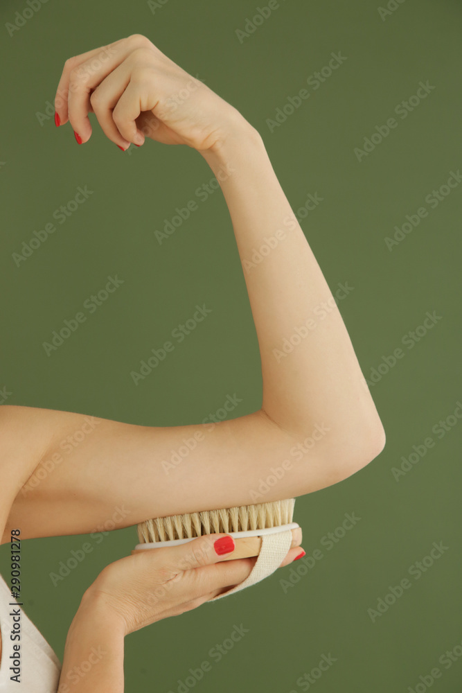 Dry body brush, Woman dry brushing body to reduce cellulite, detoxify the lymphatic system, and