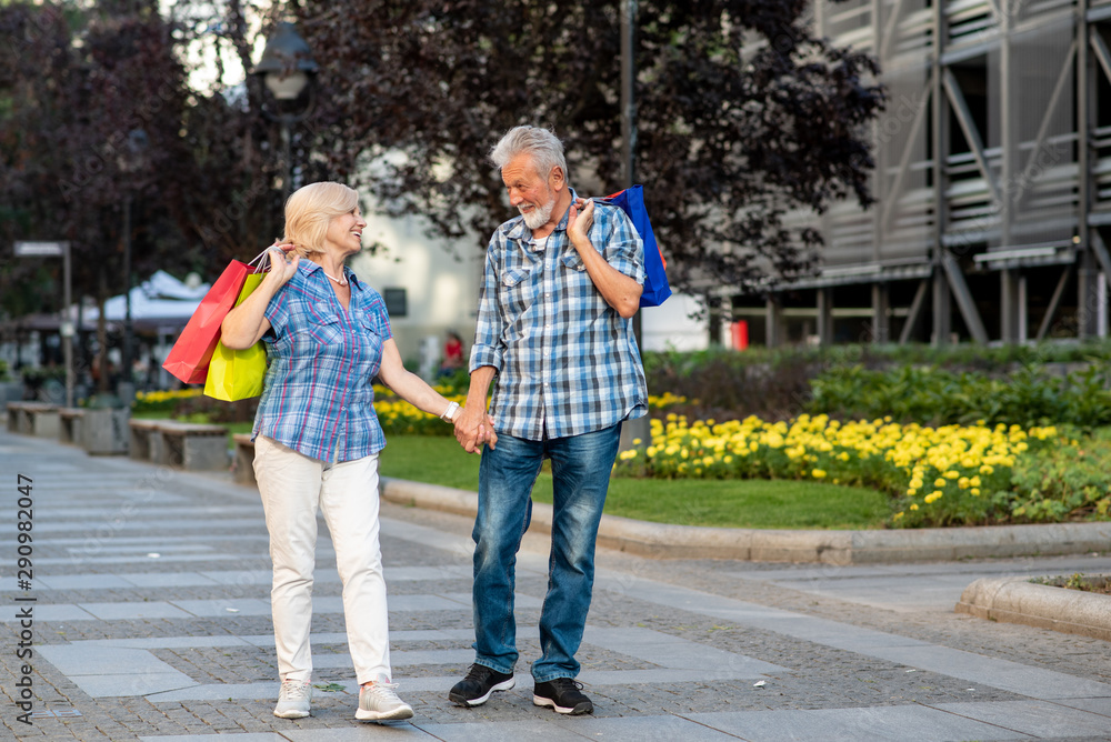 Fototapeta premium Happy senior couple with shopping bags looking at each other