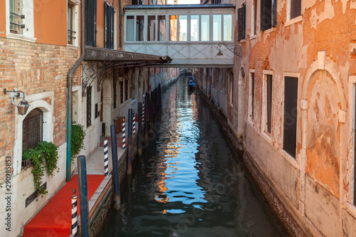 Boats on narrow canal between colorful historic houses in Venice. © k_samurkas