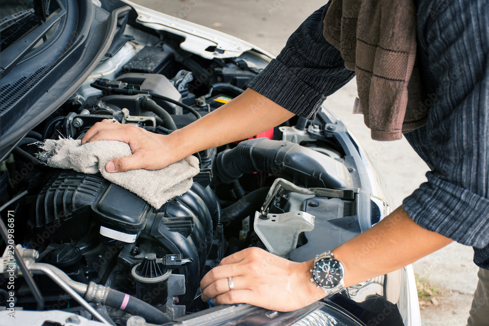 Man or auto mechanic worker hands cleaning the car engine with fabric. Man or auto mechanic worker hands cleaning the car engine with fabric.