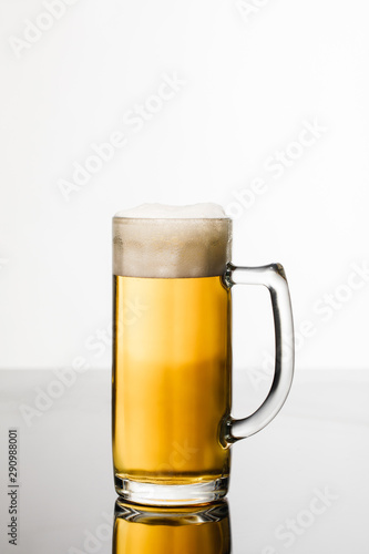 glass of beer with foam isolated on white