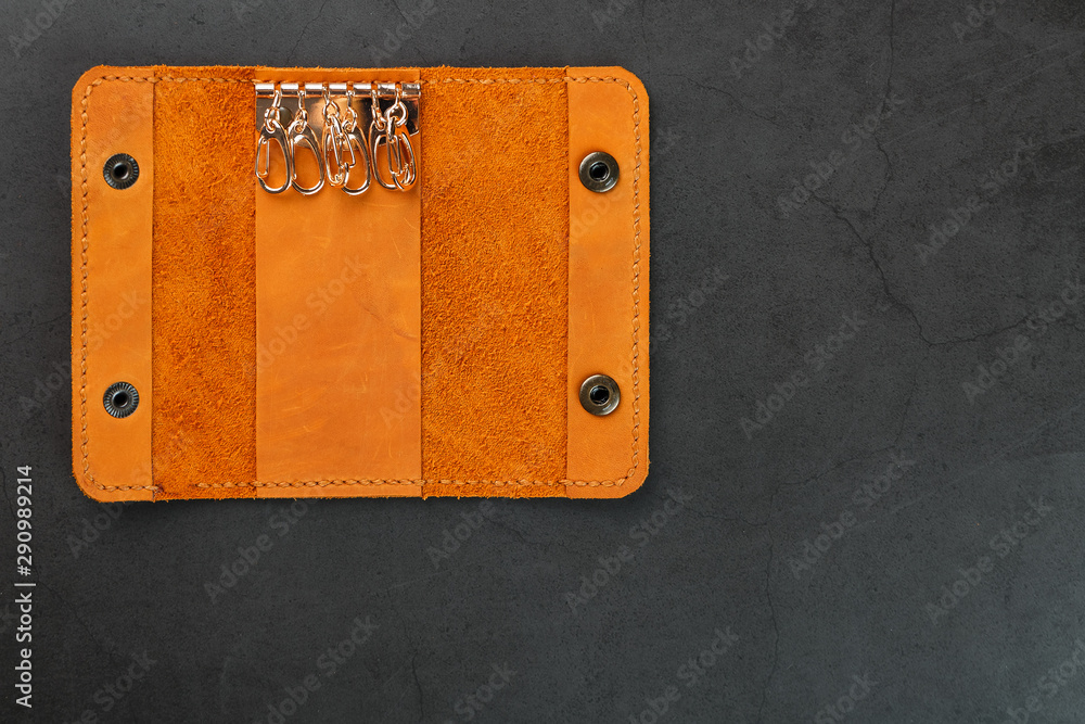 Key wallet made of genuine brown nubuck leather on a dark background. Handmade leather items
