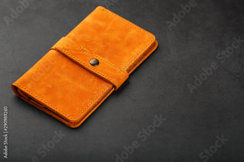 Wallet made of genuine brown nubuck leather on a dark background. Handmade leather items
