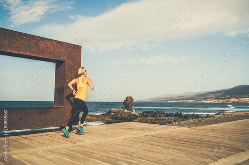 Young woman running in mountains on sunny summer day