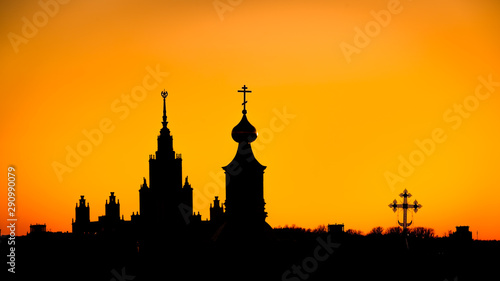 Silhouette of church and skyscraper at sunset. Travel destination Moscow, Russia