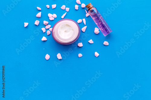 Sea salt with cream and oil for body on blue background top view mockup