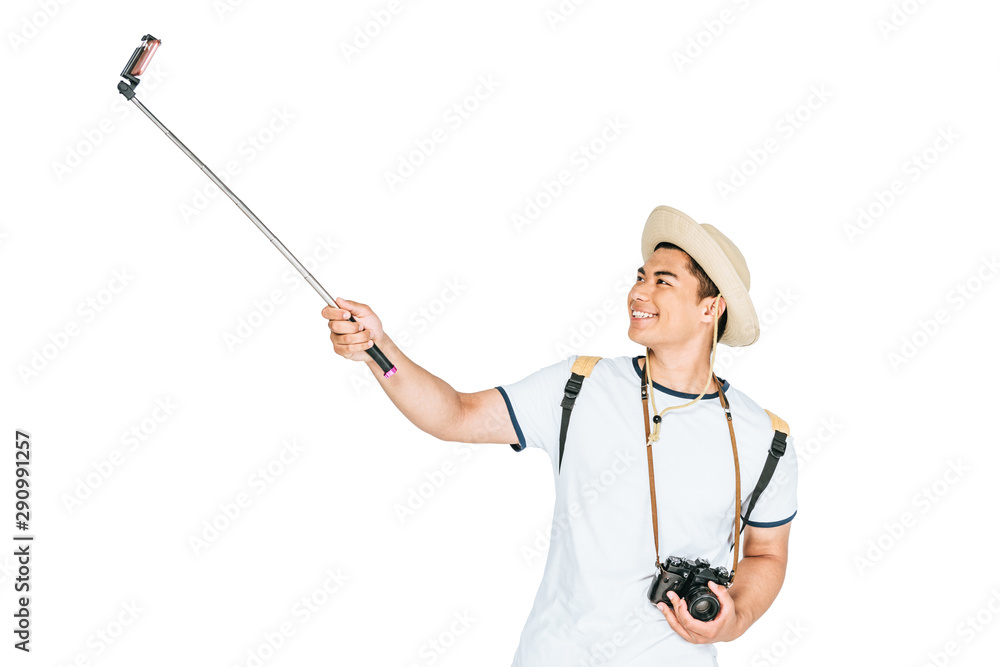 cheerful asian man taking selfie on smartphone with selfie stick isolated on white cheerful asian man taking selfie on smartphone with selfie stick isolated on white