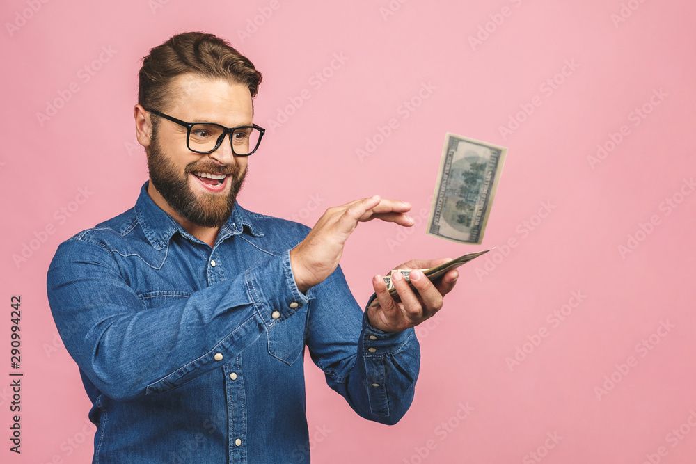 Portrait of attractive handsome reckless careless carefree guy wearing jeans shirt throwing money away wealth isolated over pink background. Portrait of attractive handsome reckless careless carefree guy wearing jeans shirt throwing money away wealth isolated over pink background.