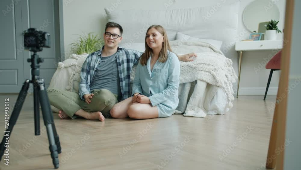 Slow motion of girl and guy recording video for online vlog in bedroom talking waving hand using professional camera. Vlogging, devices and people concept. Slow motion of girl and guy recording video for online vlog in bedroom talking waving hand using professional camera. Vlogging, devices and people concept.