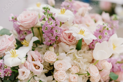 A large bouquet of fresh colors of light and pastel shades on the groom and bride 's table