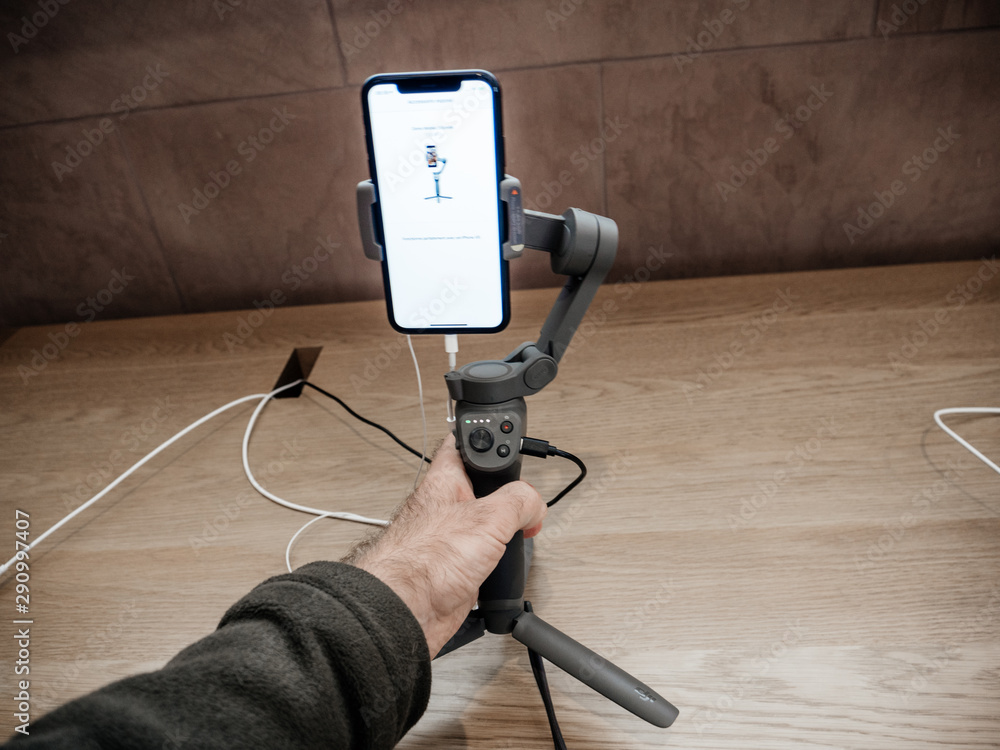 Paris, France - Sep 20, 2019: Man hand holding DJI Osmo 3 gimbal with the  new iPhone 11, 11 Pro and Pro Max are displayed in Apple Store Stock Photo  | Adobe Stock