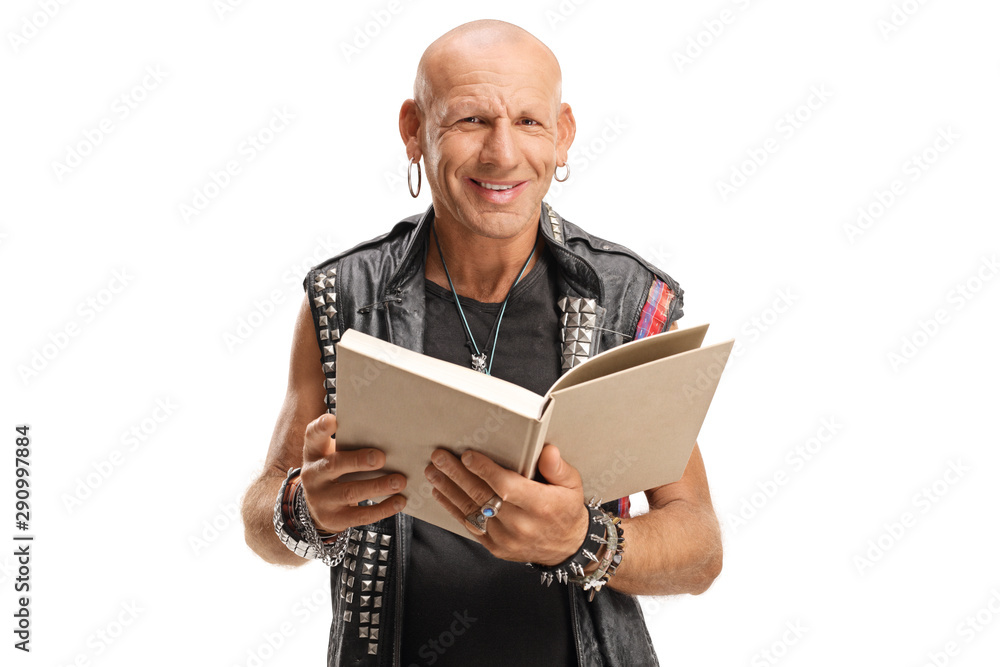 Punker in leather vest holding a book and smiling at the camera - obrazy, fototapety, plakaty 