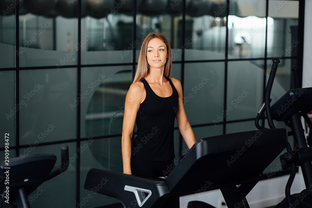 blonde woman training on a treadmill inside a gym blonde woman training on a treadmill inside a gym