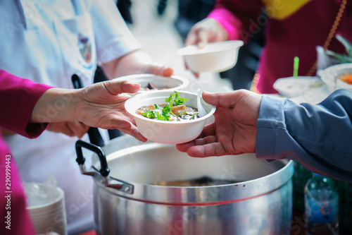 Homeless and needy people receive help, receive food from volunteers : concept of food donation