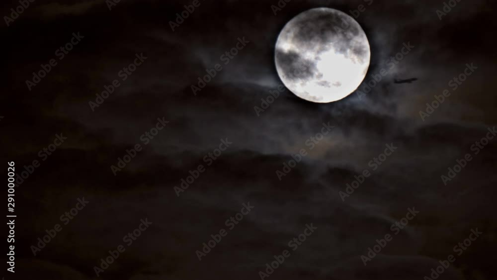 Mysterious night sky with silhouette of passenger airplane flying over full moon night Mysterious night sky with silhouette of passenger airplane flying over full moon night