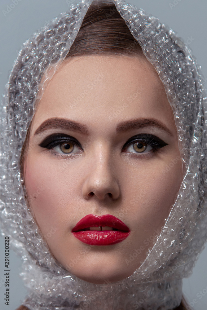 Φωτογραφία High fashion, beauty portrait of caucasian young woman model with creative cellophane head scarf