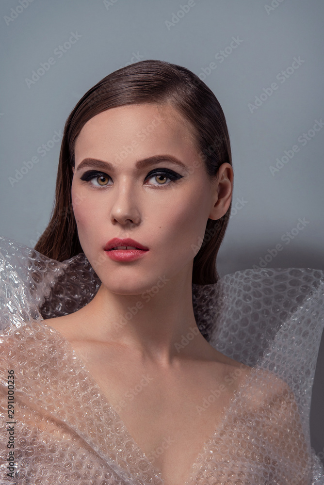 Φωτογραφία High fashion, beauty portrait of caucasian young woman model with creative cellophane dress