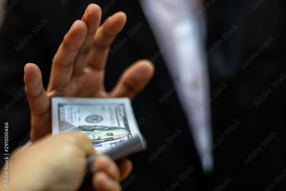 Corruption concept,Businessman manager refusing receive money from Business man passing money dollar bills corruption bribery.