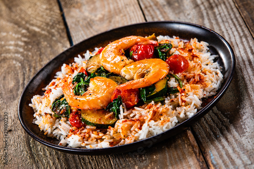 Shrimps with white rice and vegetables on wooden table