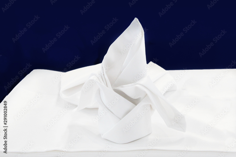 White textile napkin settled in a form of a ship White textile napkin settled in a form of a ship