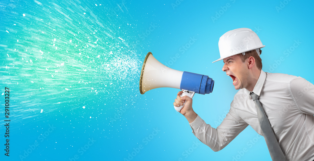 Fototapeta premium Young architect constructor yelling with megaphone and sparkling sounds
