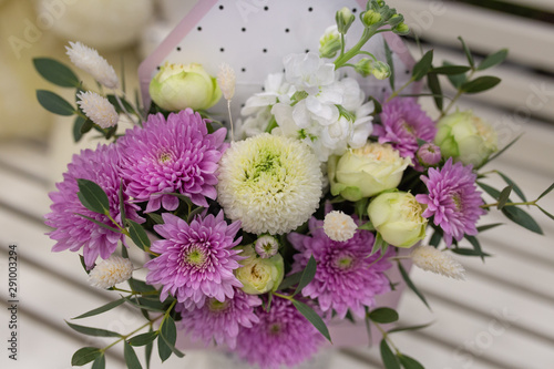 Composition of fresh flowers (chrysateme, rose, matiola. Colors light green, lilac) in a gift box in the form of an envelope photo