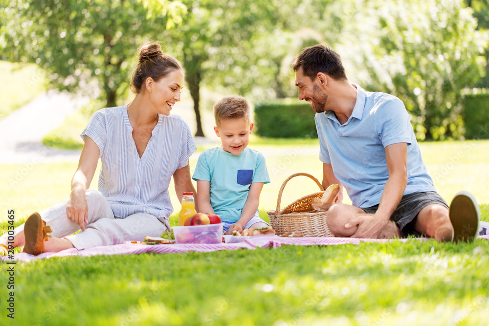 family, leisure and people concept - happy mother, father and little son having picnic at summer park family, leisure and people concept - happy mother, father and little son having picnic at summer park