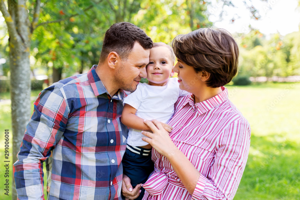 family, leisure and people concept - happy mother, father and little son at summer park family, leisure and people concept - happy mother, father and little son at summer park