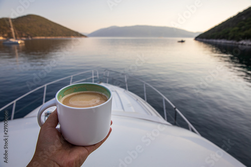 Early summer morning with cup of coffee cappuccino on a yacht in the Antisamos bay, Kefalonia island, Ionian sea, Greece.