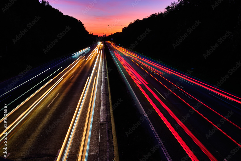Auto Lichtspuren. Lichter auf der Autobahn. Spuren von Autos. Abstraktes  Licht, Lichtschweife. Autbahn bei Sonnenuntergang und viel Verkehr.  Autobahn bei Nacht. Photos