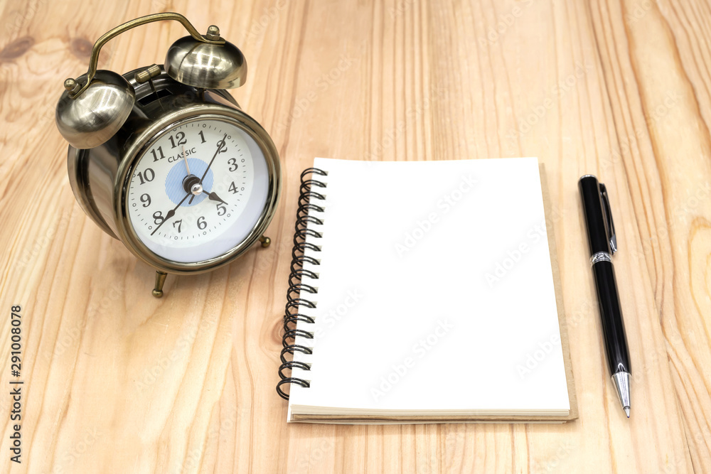 Blank notebook with pen and clock on the table Blank notebook with pen and clock on the table