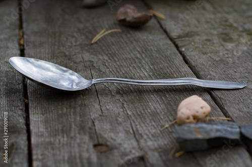 The spoon is lying on the table on the grey old wood . Design background