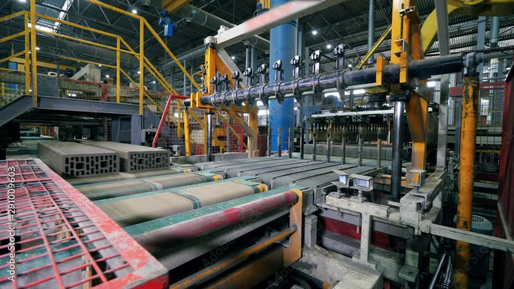Plant machine works with bricks on a conveyor. Plant machine works with bricks on a conveyor.