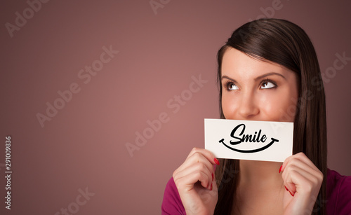 Person holding card with smile in front of her mouth
