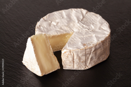 Camembert cheese is cut into pieces and whole.