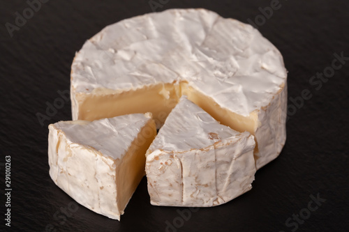 Camembert cheese is cut into pieces and whole.
