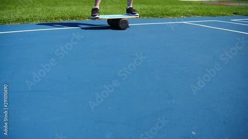 Wallpaper Mural Man on balance board doing squats, exercising, training, working out outdoors in a park on a sunny summer day, 60fps. Torontodigital.ca