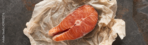 top view of raw salmon steak on bakery paper on stone table, panoramic shot