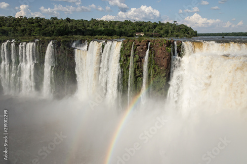 Landscape view of a rainbow over Devil s thoat  garganta del diablo  cascade at Iguazu waterfalls  Argentina on a sunny day