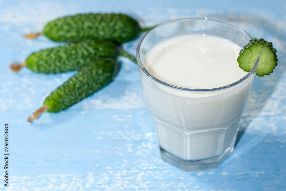 Ayran, homemade yogurt drink kefir, lassi with cucumbers - healthy summer refreshing cold drink on blue, copy space. Ayran, homemade yogurt drink kefir, lassi with cucumbers - healthy summer refreshing cold drink on blue, copy space.